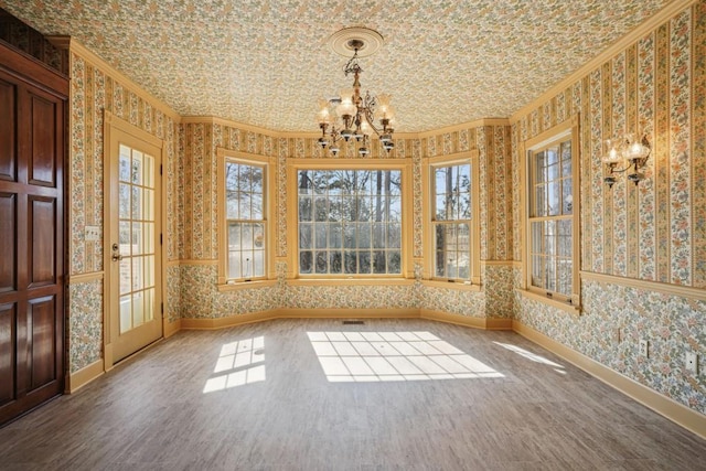 unfurnished dining area featuring wallpapered walls, crown molding, and baseboards