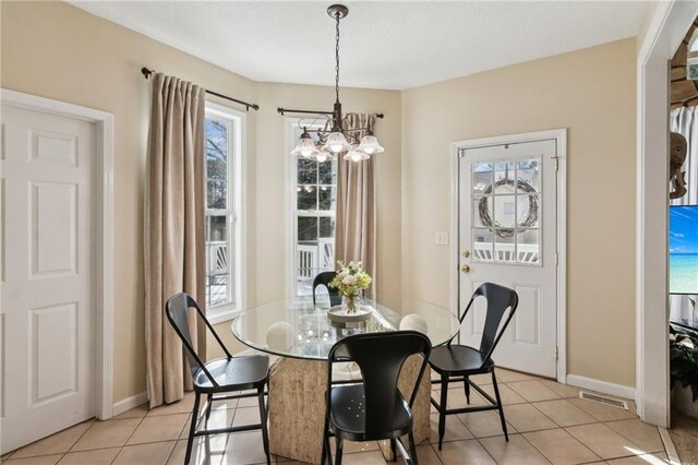 dining area with baseboards, visible vents, a chandelier, and light tile patterned flooring