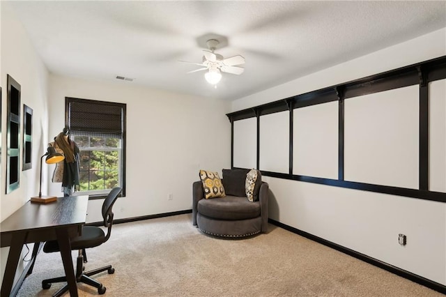 office space with visible vents, baseboards, ceiling fan, and light colored carpet