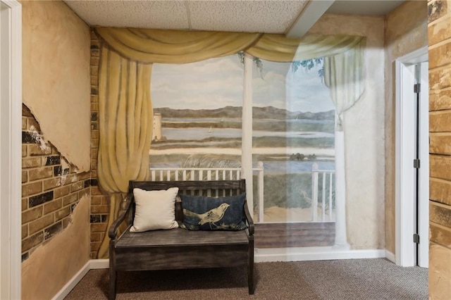 living area with brick wall, baseboards, and carpet flooring