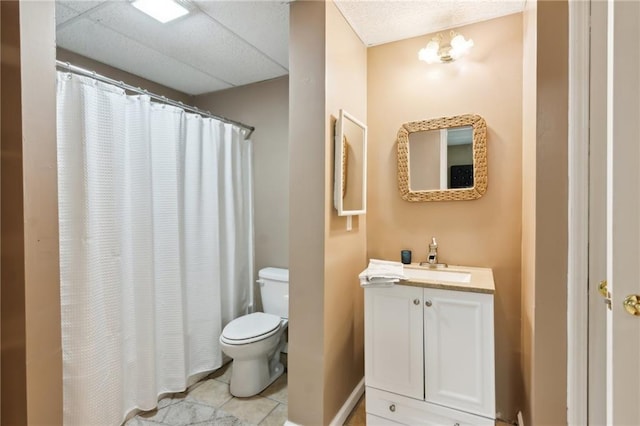 full bathroom featuring a paneled ceiling, toilet, tile patterned floors, vanity, and a shower with curtain