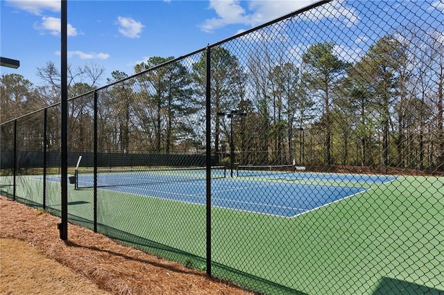 view of tennis court featuring fence