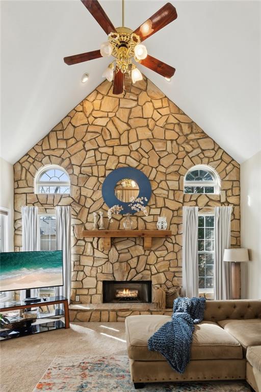 living room featuring carpet, high vaulted ceiling, a fireplace, and a ceiling fan