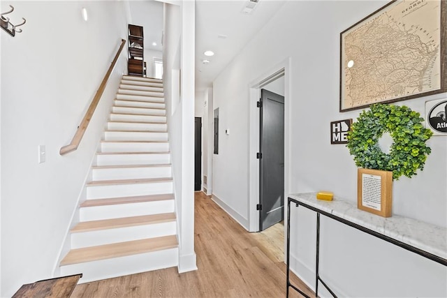 staircase featuring recessed lighting, baseboards, and wood finished floors