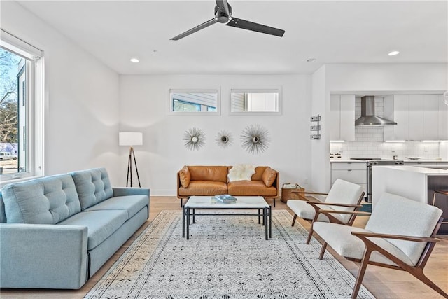 living area with light wood-style flooring, recessed lighting, and plenty of natural light