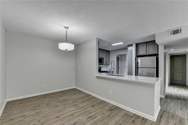 3650 Ashford Dunwoody Rd NE Unit 923, Atlanta, GA 30319 - kitchen with appliances with stainless steel finishes, a sink, baseboards, light wood-type flooring, and a peninsula