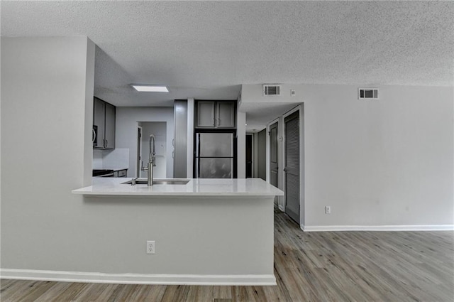 3650 Ashford Dunwoody Rd NE Unit 923, Atlanta, GA 30319 - kitchen with a sink, freestanding refrigerator, wood finished floors, light countertops, and a textured ceiling