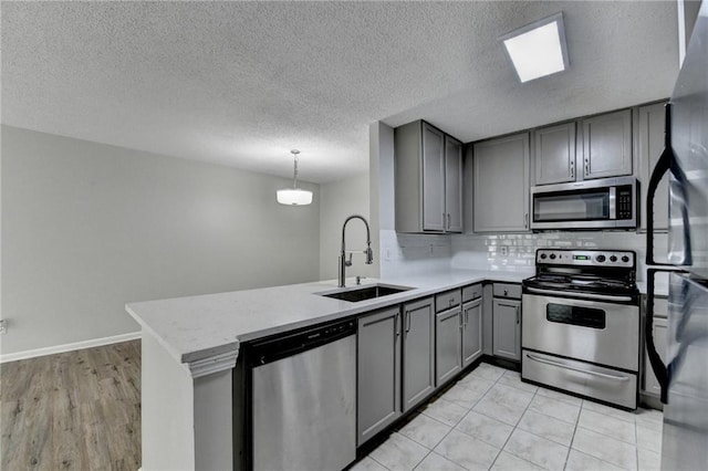 3650 Ashford Dunwoody Rd NE Unit 923, Atlanta, GA 30319 - kitchen featuring appliances with stainless steel finishes, gray cabinets, a sink, backsplash, and light countertops