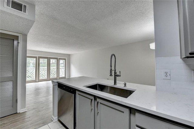 3650 Ashford Dunwoody Rd NE Unit 923, Atlanta, GA 30319 - kitchen with dishwashing machine, a sink, gray cabinetry, open floor plan, and a textured ceiling