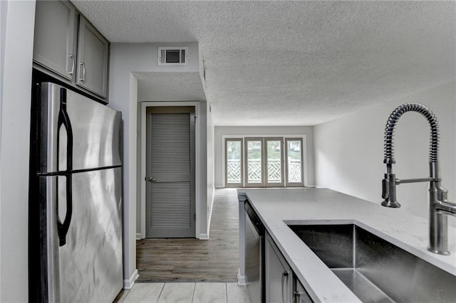 3650 Ashford Dunwoody Rd NE Unit 923, Atlanta, GA 30319 - kitchen with appliances with stainless steel finishes, a sink, light stone counters, a textured ceiling, and gray cabinets