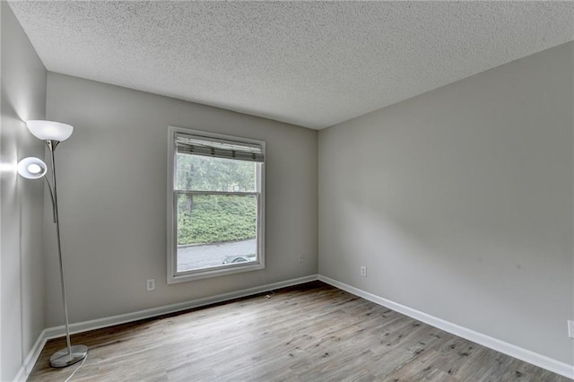 3650 Ashford Dunwoody Rd NE Unit 923, Atlanta, GA 30319 - unfurnished room with wood finished floors, a textured ceiling, and baseboards