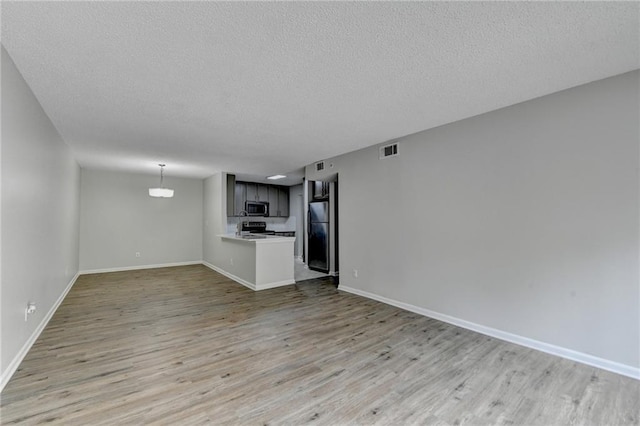3650 Ashford Dunwoody Rd NE Unit 923, Atlanta, GA 30319 - unfurnished living room featuring light wood finished floors, a textured ceiling, and baseboards