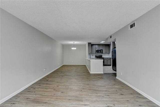 3650 Ashford Dunwoody Rd NE Unit 923, Atlanta, GA 30319 - unfurnished living room featuring light wood-style flooring, a sink, baseboards, and a textured ceiling
