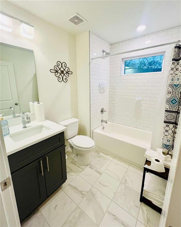 bathroom with shower / tub combo, visible vents, toilet, marble finish floor, and vanity