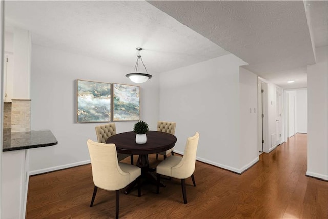 dining area featuring dark hardwood / wood-style floors and a textured ceiling