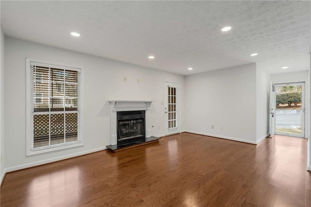 unfurnished living room featuring dark hardwood / wood-style floors and a textured ceiling