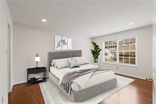 bedroom with hardwood / wood-style floors and a textured ceiling