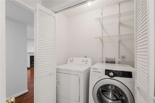 laundry area with dark wood-type flooring and washing machine and dryer