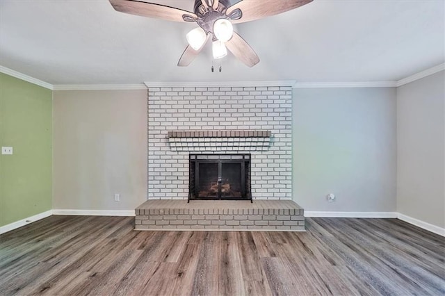 5666 Goldfield Dr, Acworth, GA 30102 - unfurnished living room with wood finished floors, baseboards, crown molding, a ceiling fan, and a brick fireplace