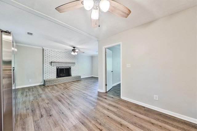 5666 Goldfield Dr, Acworth, GA 30102 - unfurnished living room featuring a ceiling fan, baseboards, wood finished floors, ornamental molding, and a fireplace