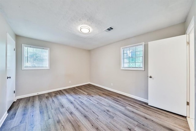 5666 Goldfield Dr, Acworth, GA 30102 - unfurnished bedroom featuring multiple windows, wood finished floors, baseboards, and a textured ceiling
