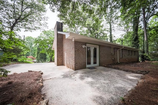 5666 Goldfield Dr, Acworth, GA 30102 - back of property with french doors, a chimney, and brick siding