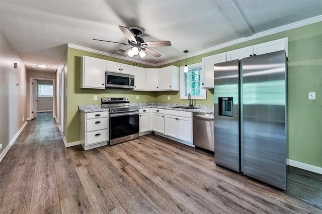 5666 Goldfield Dr, Acworth, GA 30102 - kitchen featuring stainless steel appliances, white cabinets, plenty of natural light, dark wood-style flooring, and crown molding