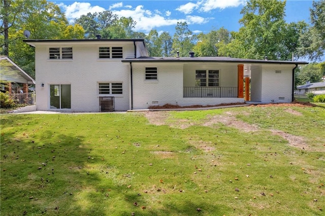 rear view of property with cooling unit and a yard