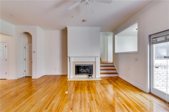 unfurnished living room with wood-type flooring, crown molding, and a wealth of natural light