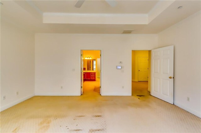 carpeted empty room featuring a tray ceiling