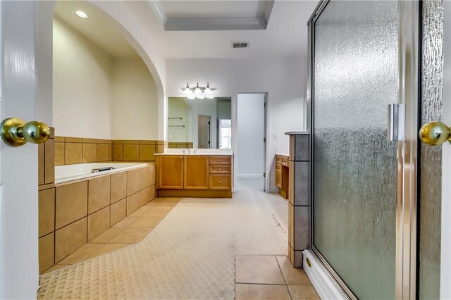 bathroom with tile patterned floors, a raised ceiling, vanity, and separate shower and tub