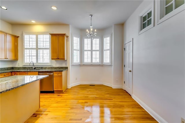 kitchen with light hardwood / wood-style flooring, decorative light fixtures, stainless steel dishwasher, sink, and a notable chandelier