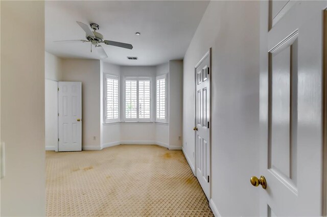 carpeted spare room featuring ceiling fan