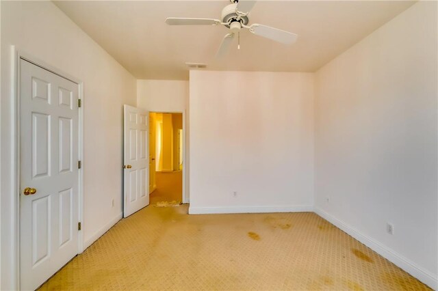 empty room with ceiling fan and light colored carpet