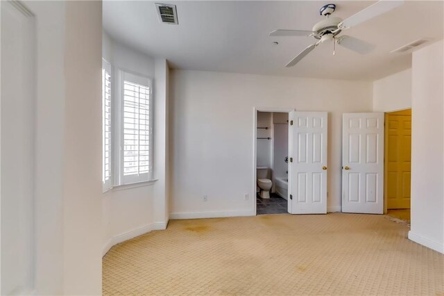 unfurnished bedroom with carpet, connected bathroom, and ceiling fan