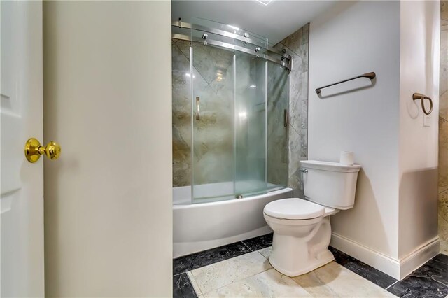 bathroom featuring enclosed tub / shower combo and toilet