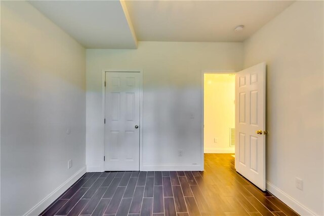 unfurnished bedroom with dark wood-type flooring