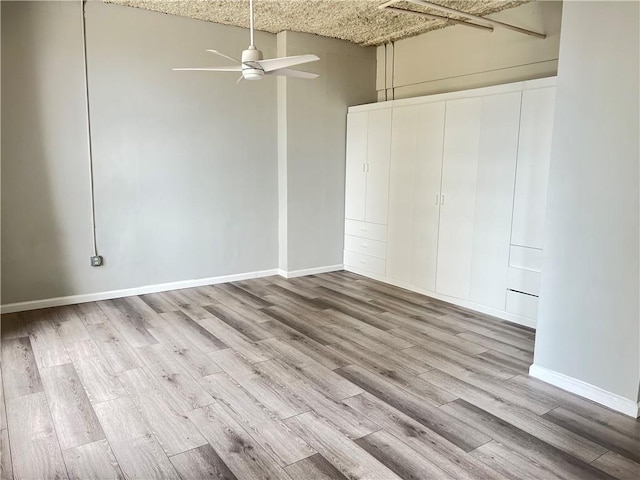 unfurnished bedroom with wood finished floors, baseboards, and a closet