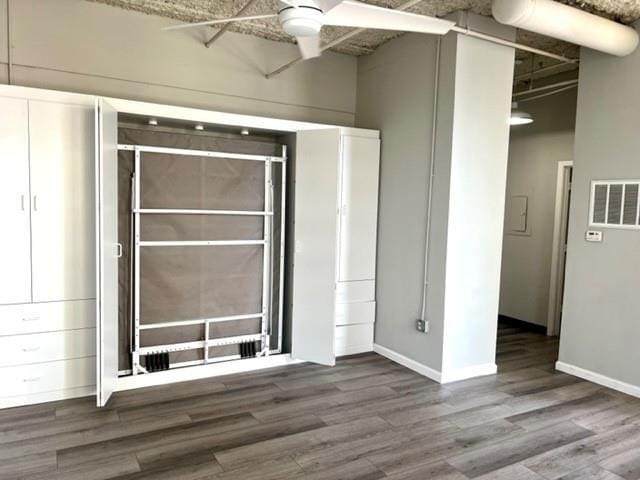 spare room with wood finished floors, baseboards, and a ceiling fan
