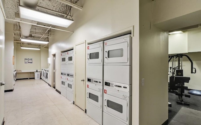 hall featuring stacked washing machine and dryer and a high ceiling