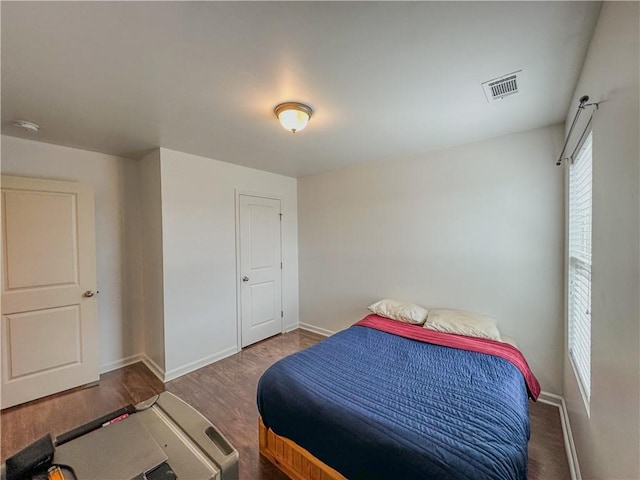 bedroom with dark hardwood / wood-style flooring