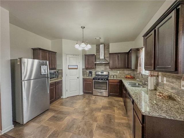 kitchen featuring wall chimney exhaust hood, sink, dark brown cabinets, hanging light fixtures, and stainless steel appliances