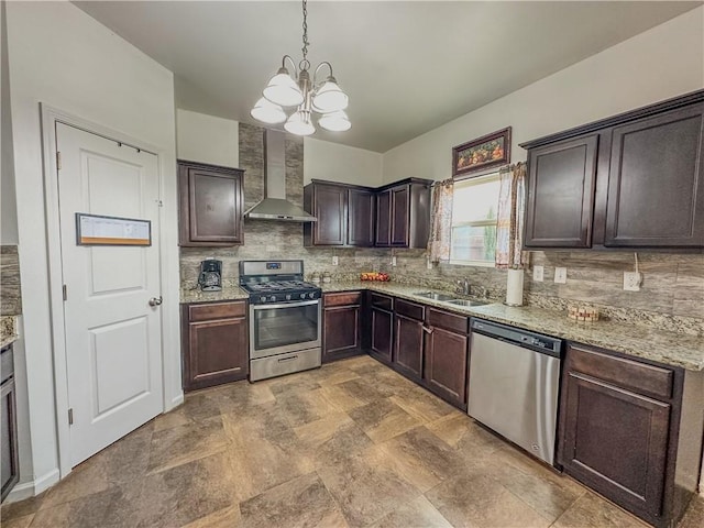 kitchen featuring sink, appliances with stainless steel finishes, dark brown cabinets, decorative light fixtures, and wall chimney exhaust hood