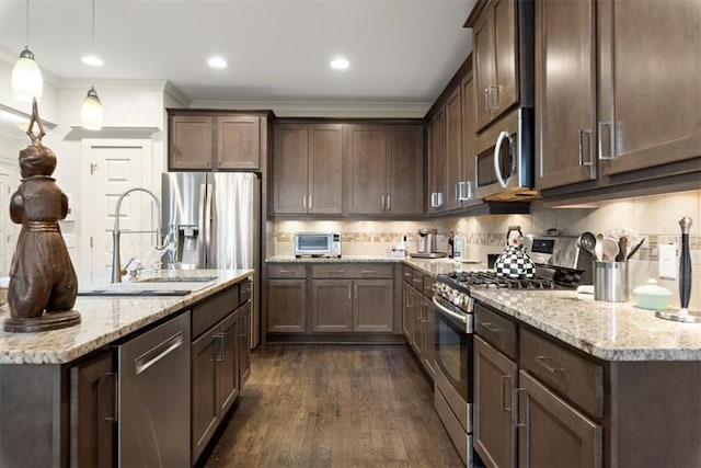 kitchen with stainless steel appliances, dark brown cabinetry, pendant lighting, and dark wood-type flooring