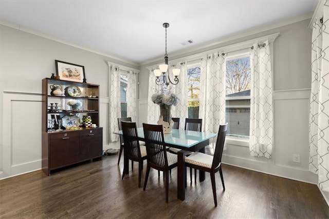 dining area with a notable chandelier, dark hardwood / wood-style flooring, and crown molding