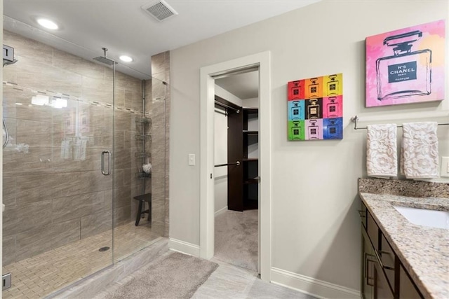 bathroom featuring walk in shower, tile patterned floors, and vanity