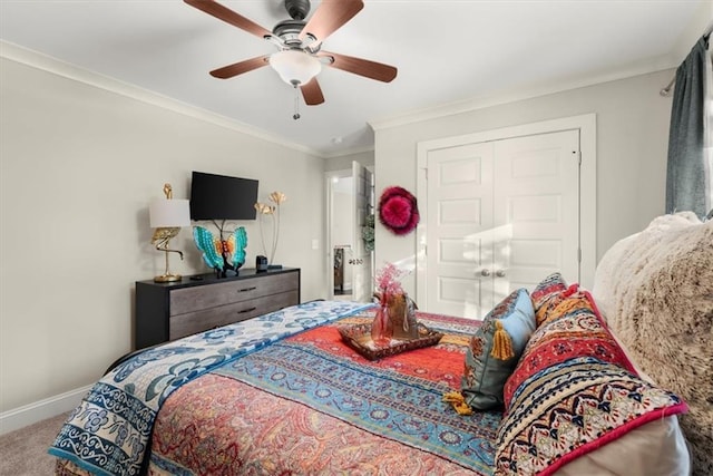 carpeted bedroom featuring ceiling fan, crown molding, and a closet