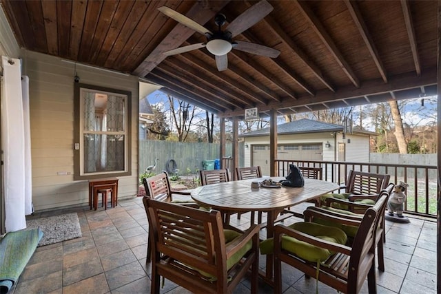 sunroom / solarium with lofted ceiling with beams, ceiling fan, plenty of natural light, and wood ceiling