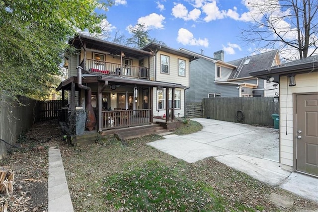 back of house featuring covered porch and a balcony