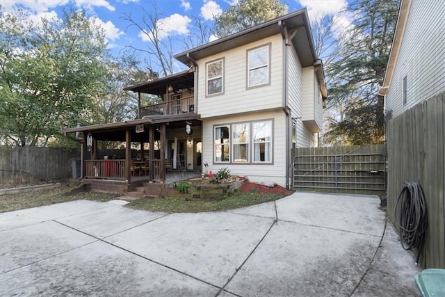 rear view of house with a balcony and a patio